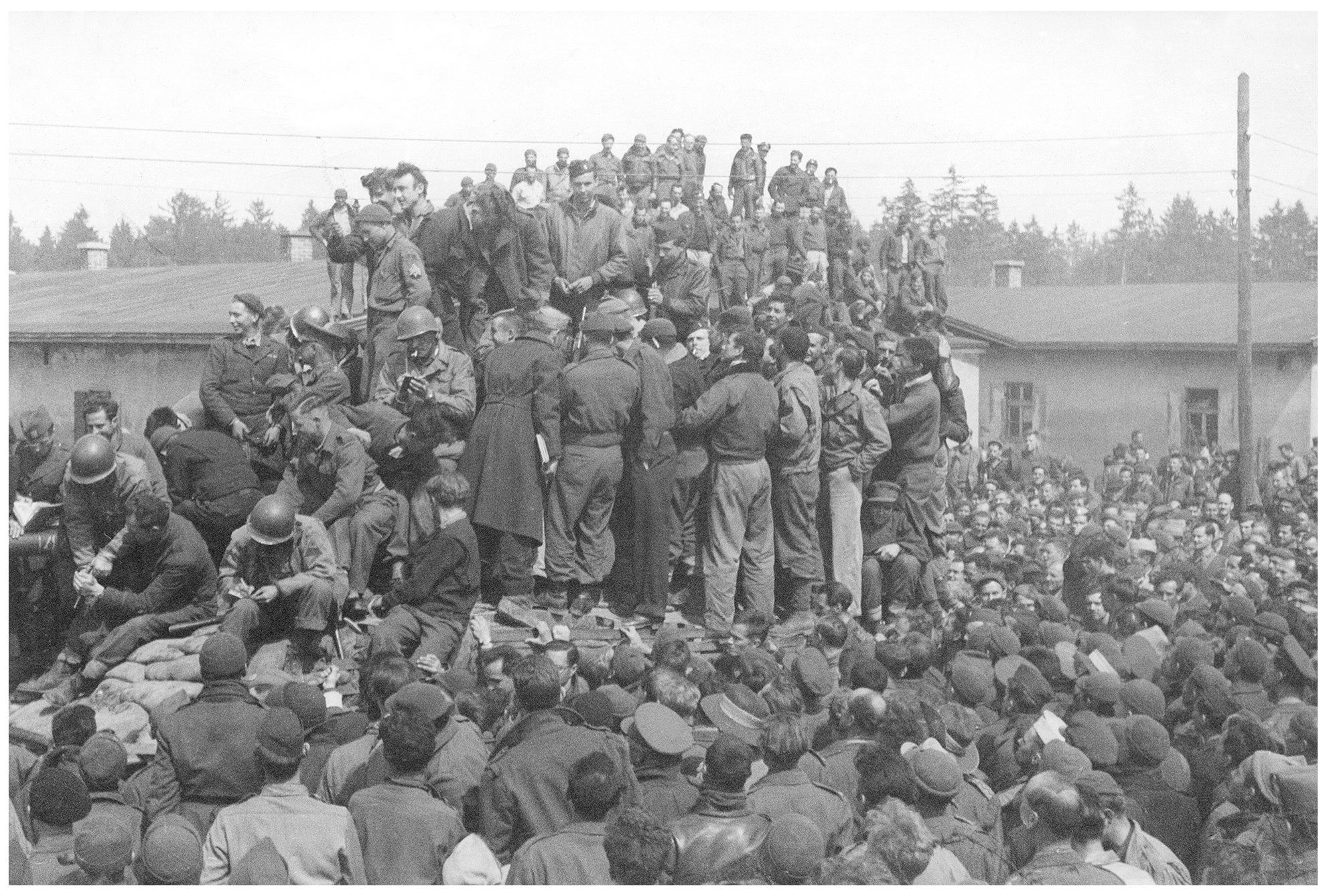 image of POWs standing on American tank that entered the camp.